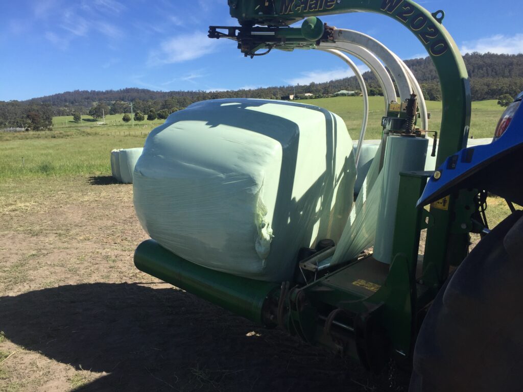 Baling with silage wrap in an open field.